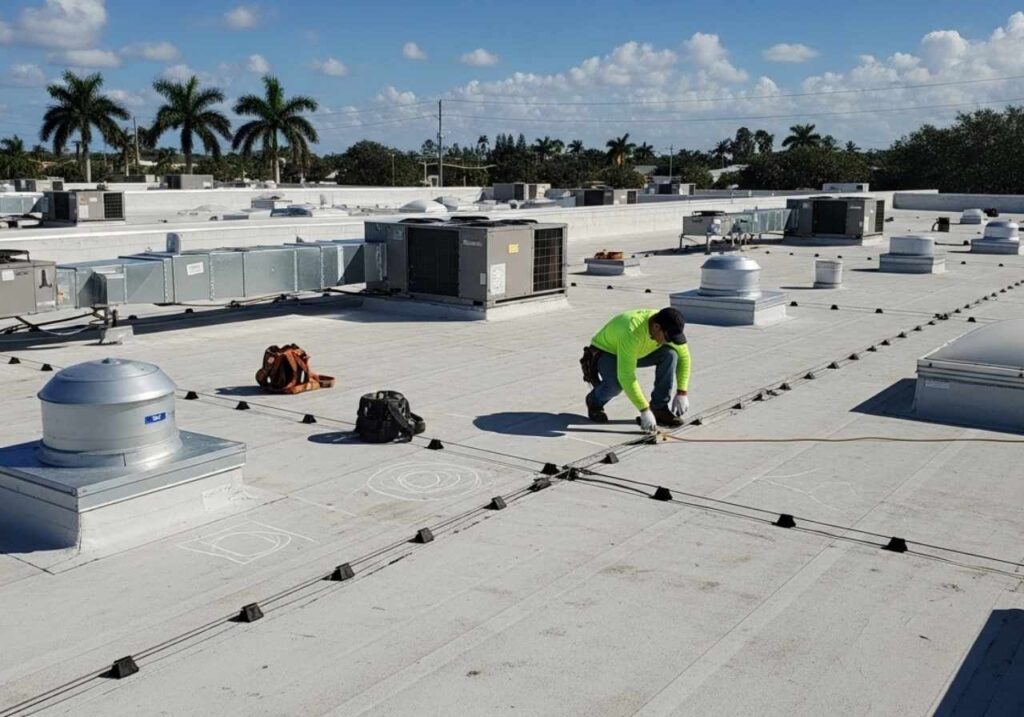 Roofing contractor inspecting a complex flat roof with HVAC units and seam repairs in Florida.